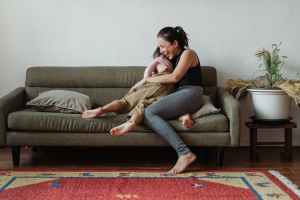 Frau mit Kind auf gemütlichem Sofa.